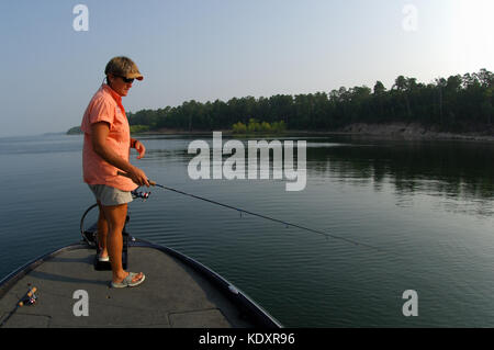 A woman fishes for crappie from her boat on Lake Sam Rayburn near Jasper Texas Stock Photo