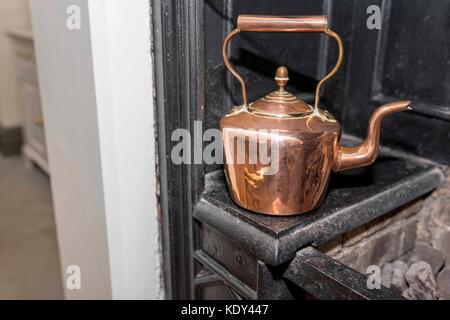 Vintage and antique copper kettle on a Victorian stove in a traditional Victorian kitchen in England, United Kingdom Stock Photo