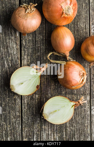Fresh onion bulbs on old wooden table. Stock Photo