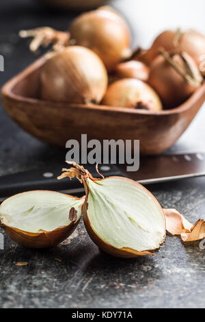 Halved onion bulbs on old kitchen table. Stock Photo