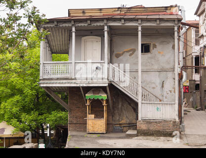 Side view of a traditional building in the Georgoan capital Tbilisi, wooden balcony and balustrade, small kiosk Stock Photo