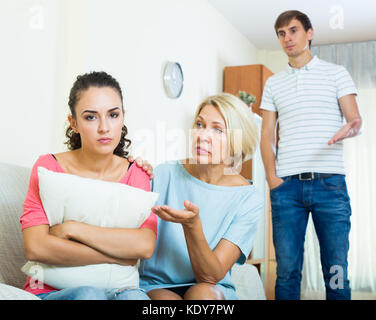 Mature woman helping offended daughter to reconcile with husband Stock Photo