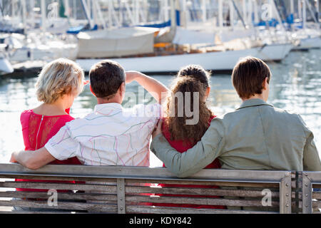 Normal ordinary family of four enjoying the sunny spring day together near sea Stock Photo