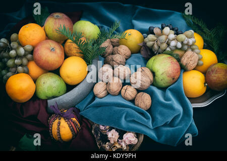 Autumn fruit and nut display with apples oranges and walnuts. Applied vintage faded filter Stock Photo