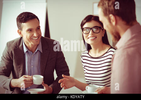 Joyful nice colleagues having coffee Stock Photo