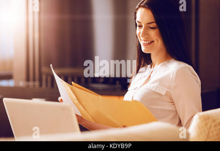 Smiling female checking important documents Stock Photo