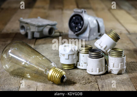 Old ceramic fuse holders. Old electrical accessories. Wooden table, black background Stock Photo