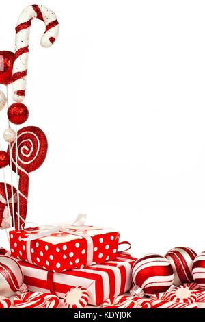 Red and white Christmas corner border with gifts, baubles and candy against white background Stock Photo
