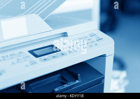 Man holding finger on start button of laser printer Stock Photo
