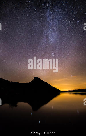 Milky Way night shot with Andromeda galaxy in the distance and Light pollution from nearby town Dolgellau, Cregennan Lakes, Wales, UK Stock Photo