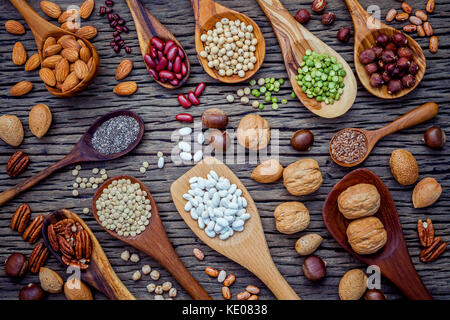 Various legumes and different kinds of nutshells in spoons. Walnuts kernels ,hazelnuts, almond ,brown pinto ,soy beans ,flax seeds ,chia ,chickpea ,re Stock Photo