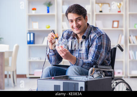 Computer repairman on wheelchair working Stock Photo