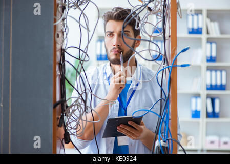 Electrician trying to untangle wires in repair concept Stock Photo