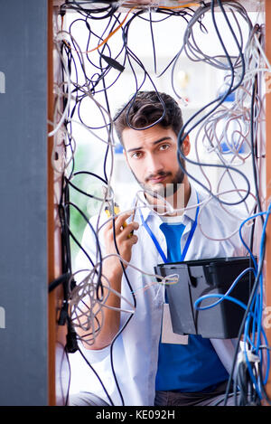 Electrician trying to untangle wires in repair concept Stock Photo