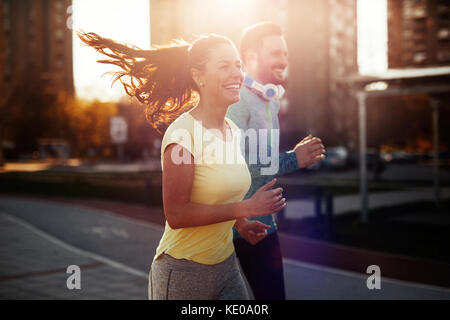 Young attractive couple running outside on sunny day Stock Photo