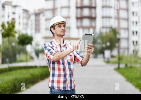 Young architect in front of apartment building Stock Photo