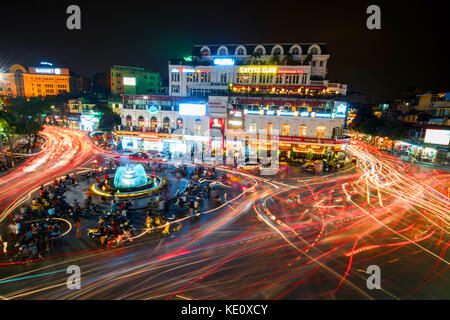 HANOI, VIETNAM - MAY 21, 2016: People and vehicles  light trails crowd on busy intersection locating next to Hoan Kiem  lake in old quarter of Hanoi c Stock Photo
