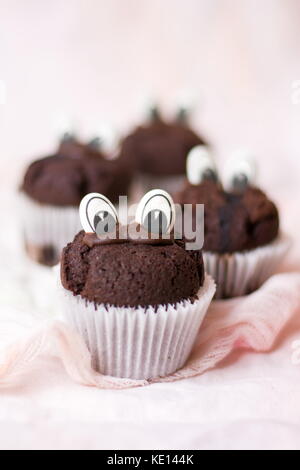 Chocolate muffins with edible eyes in paper holders Stock Photo