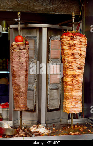 Turkish chicken and meat doner grilled on a vertical rotisserie. Stock Photo