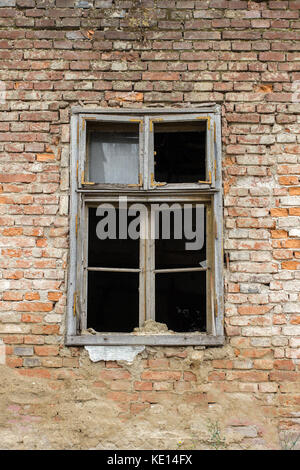 Old broken window on a old abandoned brick wall house Stock Photo