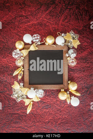 Golden and white glass ornaments for christmas on dark red background Stock Photo