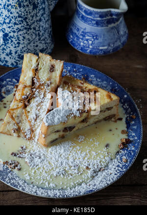 Jumbo french toast stuffed with bananas, roasted pecans and caramel on rustic background Stock Photo