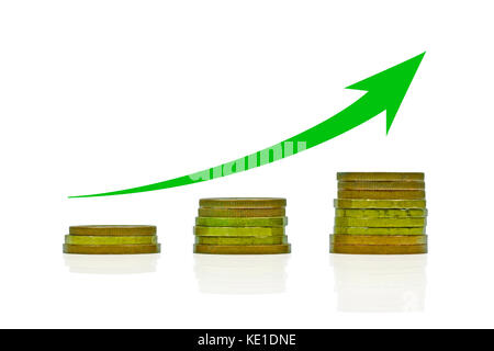 Close-up view of three stacks of coins arranged in a growing chart with green arrow, isolated on a white background Stock Photo