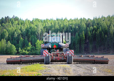 SALO, FINLAND - MAY 27, 2016: Rear view of John Deere 9520T tracked tractor and cultivator on stubble field at spring. The farmer is ready to cultivat Stock Photo