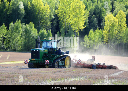 SALO, FINLAND - MAY 27, 2016: John Deere 9520T agricultural crawler tractor and cultivator on field at spring in South of Finland. Stock Photo