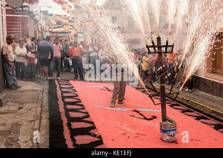 Fire on street decorated with coloured salt during Fiesta del Carmen celebrations. La Isleta, Las Palmas, Gran Canaria, Canary Islands, Spain Stock Photo