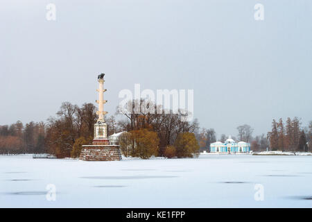 Chesme column and Grotto Pavilion on frozen pond in snowfall, early November winter. Catherine Park of Tsarskoye Selo, Pushkin, Saint-Petersburg, Russ Stock Photo