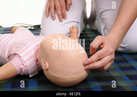 Infant first aid series - First aid instructor showing how to check pulse on infant dummy anterior fontanelle Stock Photo