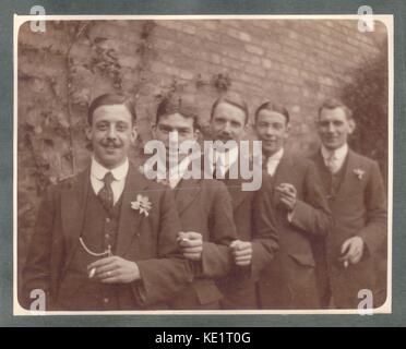 Early 1900s men at wedding with smiling groom, just married, with his best man and friends or ushers all smoking cigarettes, circa 1915, U.K. Stock Photo