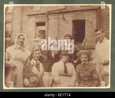 Early 1900s photograph of young men in fancy dress costume, one probably dressed as Charlie Chaplin with a battered top hat. The groom on the left is dressed as a milk maid. An early stag party night circa 1915, U.K. Stock Photo