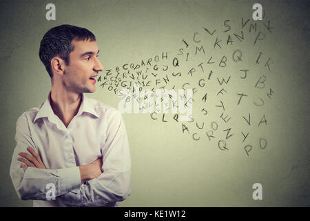 Side profile man talking with alphabet letters coming out of his mouth. Communication, information, intelligence concept Stock Photo