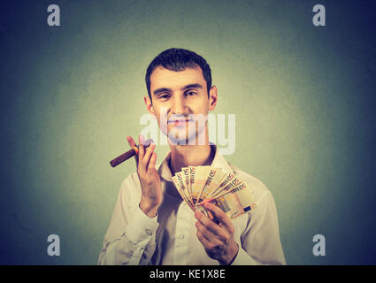 Happy young confident man with euro banknotes money and cigar Stock Photo