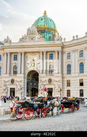 VIENNA, AUSTRIA - AUGUST 28: Tourists in a horse-drawn carriage called Fiaker at the imperial Hofburg palace in Vienna, Austria on August 28, 2017. Stock Photo