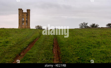 View across a grass field on top of Broadway hill to the Cotswold stone Broadway Tower in the Cotswolds. Stock Photo