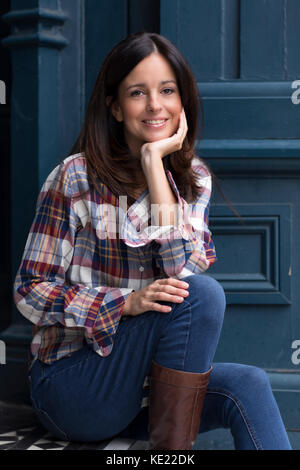 young woman sitting on her doorstep Stock Photo