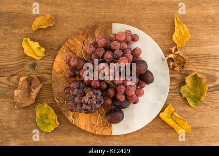 Grapes and plums on vintage plate Stock Photo