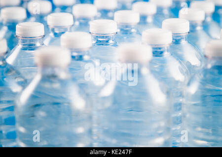 Side view of plastic water bottles in a row. Concept of factory production, recycling, disposal of waste, and environmental conservation. Stock Photo