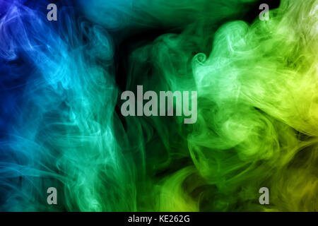 Colored smoke. Green and blue mist on black background. Stock Photo