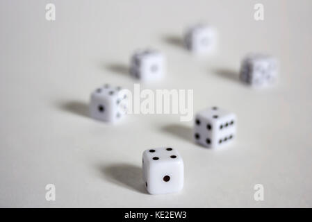 White dices in a row or scattered on white background soft focus Stock Photo