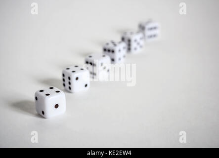 White dices in a row or scattered on white background soft focus Stock Photo