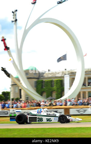 A historic F1 car drives past the Bernie Ecclestone sculpture at the 2017 Goodwood Festival of Speed. Stock Photo