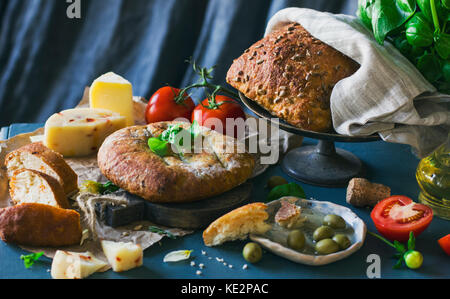 Grain bread, cheese and tomatoes on blue background Stock Photo