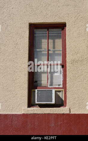 Window with air conditioning unit and closed blinds Stock Photo