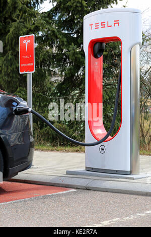 PAIMIO, FINLAND - APRIL 29, 2016: Tesla Supercharger Station with black Tesla Model S electric vehicle being charged. Charging the battery from 10 to  Stock Photo