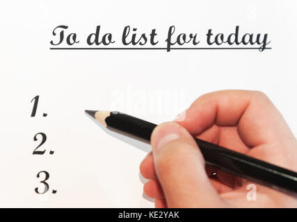 A sheet of paper in front of a man with the words: To do list for today . Planning of affairs for the day. The concept. Stock Photo