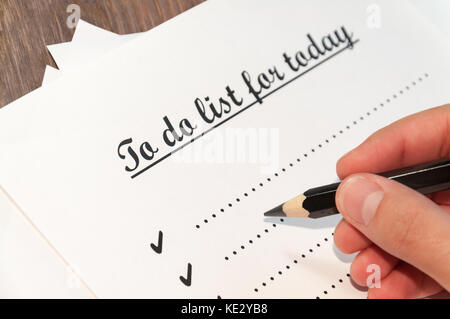 A sheet of paper in front of a man with the words: To do list for today . Planning of affairs for the day. The concept. Stock Photo